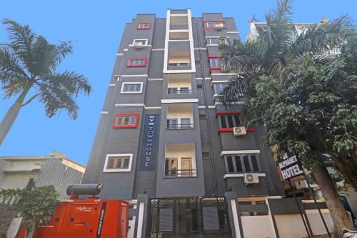 a tall gray building with red windows and palm trees at Townhouse 1014 De Alphabet Hotel in Gachibowli