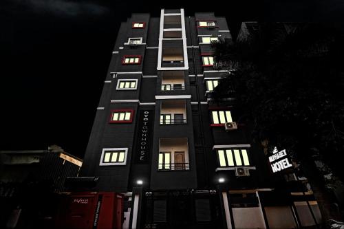 ein hohes schwarzes Gebäude mit beleuchteten Fenstern in der Nacht in der Unterkunft Townhouse 1014 De Alphabet Hotel in Gachibowli