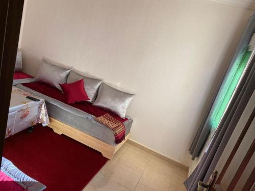 a bed with books and pillows in a room at APPARTEMENT AL WAHDA in Taza