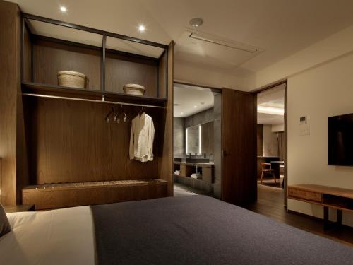 a bedroom with a bed with a wooden wall at HIDEOUT in Kyoto