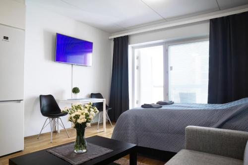 a bedroom with a bed and a vase of flowers on a table at Top location IICenter IIParking in Oulu