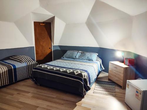 1 dormitorio con 2 camas y suelo de madera en DOMO CAMPING, en Bahía Inglesa