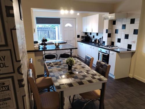 a kitchen with a table and chairs in a kitchen at #Nottingham entire house, #Hucknall in Hucknall