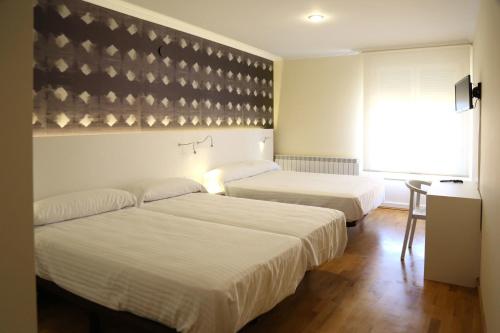 洛斯阿爾科斯的住宿－洛斯阿爾科斯旅館，酒店客房设有两张床和窗户。