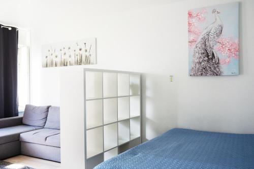 a bedroom with a bed and a couch and a painting at 2-Room City center, parking in Oulu