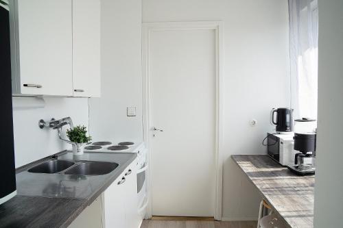 a white kitchen with a sink and a counter at 2-Room City center, parking in Oulu