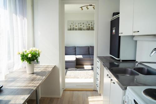 a kitchen with a sink and a living room at 2-Room City center, parking in Oulu