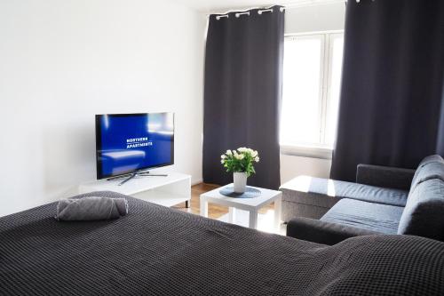 a bedroom with a bed and a couch and a tv at 3-Room Central Railway station in Oulu