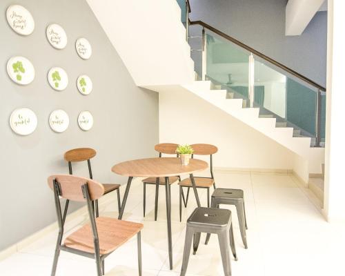 a table and chairs in a room with stairs at The Duyong Dream in Melaka