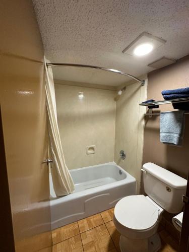 a bathroom with a toilet and a bath tub at Lone Star Inn & Suites in Harlingen