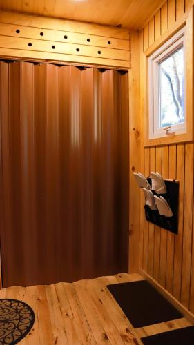 a room with a wood paneled wall and a window at Cabañas Loft Alto Arrayan Cochamó in Cochamó