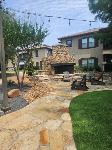a stone patio with a picnic table and a stone fireplace at LUX COMFORT in Arlington
