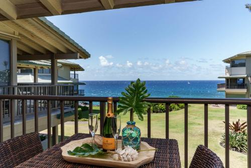 a table with wine bottles and glasses on a balcony at Kapalua Bay Villa 29B4 villa in Kahana