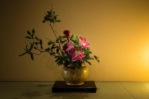 a vase filled with flowers sitting on a table at Hakone Yumoto Onsen Hotel Kajikaso in Hakone