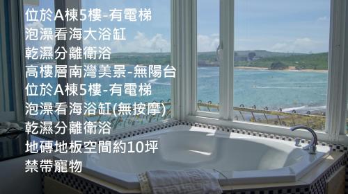 a bathroom with a bath tub in front of a window at 南灣飯店 Kenting Nanwan Hotel in Nanwan