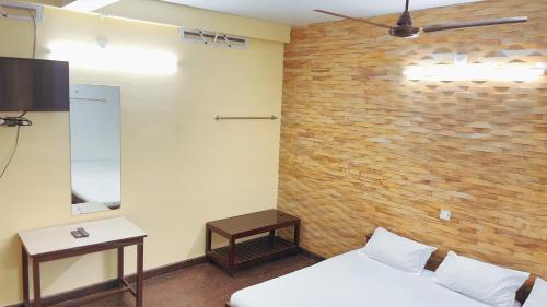 a room with two beds and a brick wall at PPG HOMES in Ernakulam