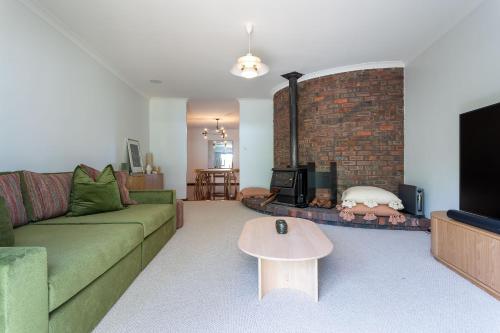a living room with a couch and a fireplace at Summer of 81 I Private Properties in Vasse