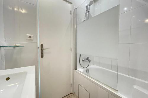a white bathroom with a shower and a tub at Le vieux MassyRER600mOrly20 minNetflixNeuf M13 in Massy