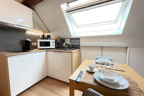 a small kitchen with a table and a window at Le vieux MassyRER600mOrly20 minNetflixNeuf M13 in Massy