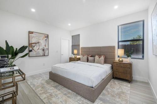 een witte slaapkamer met een groot bed en een raam bij Villa RendezVous- Stunning 4BDR with Pool by VIAC in Fort Lauderdale