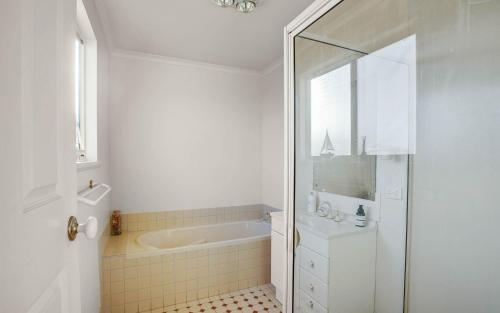 ein weißes Badezimmer mit einer Badewanne und einem Waschbecken in der Unterkunft 11 Ellensford Terrace in Middleton