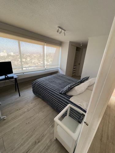 1 dormitorio con litera, escritorio y ventana en Departamento con insuperable vista Playa Amarilla Playa La Boca, en Concón