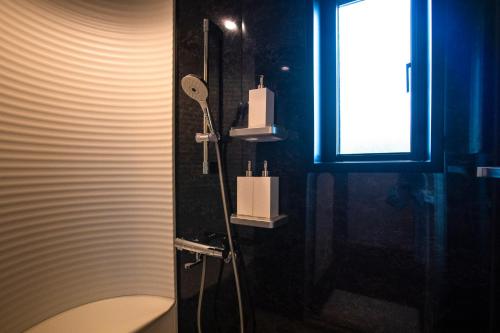 a bathroom with a shower with a toilet and a window at The Villa Miyako in Hirara
