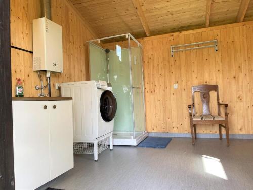 una camera con lavatrice e sedia di Holiday home FÄRGELANDA VI a Färgelanda