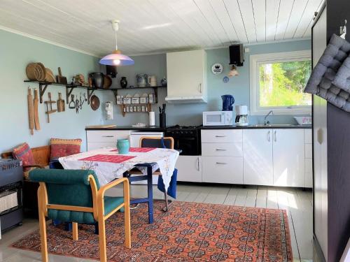 Holiday home FÄRGELANDA VI في Färgelanda: مطبخ مع طاولة وكراسي وطاولة ومطبخ