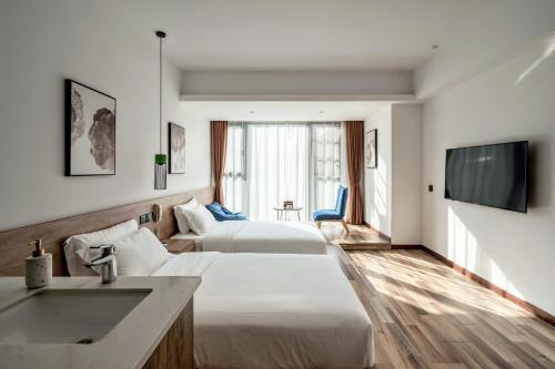 una camera d'albergo con due letti e un lavandino di National Forest Park(Yangjiajie ) MINI Inn a Zhangjiajie