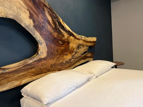 een slaapkamer met een bed met een houten hoofdeinde bij Hotel La Bikina in Tequila