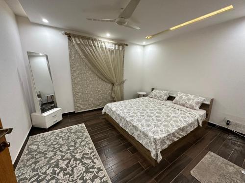 1 dormitorio con cama y espejo. en 2 Bed Apartment near Gulberg en Lahore