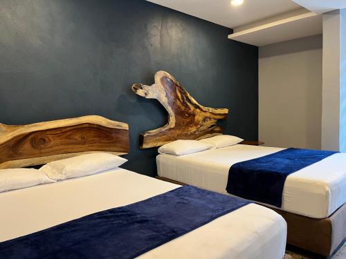 two beds in a room with two logs on the wall at Hotel La Bikina in Tequila