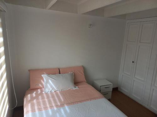 Un dormitorio con una cama con una almohada blanca. en Habitación con cama doble y baño privado, para descansar, en Bogotá