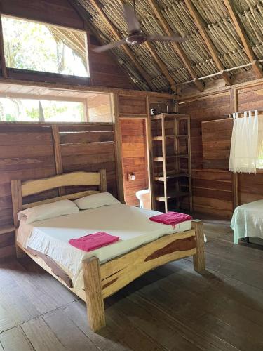 a bedroom with a bed in a wooden cabin at Cabanas Las Estrellas in Palomino