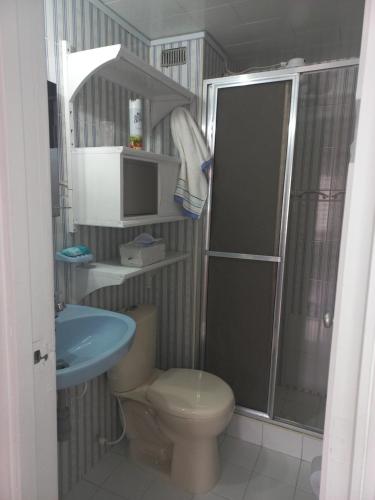 y baño con aseo, lavabo y ducha. en Habitación con cama doble y baño privado, para descansar, en Bogotá
