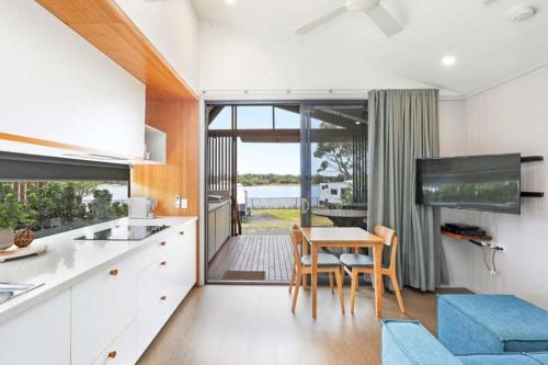 a kitchen and dining room with a table and chairs at Reflections Shaws Bay - Holiday Park in Ballina