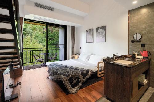 a hotel room with a bed and a balcony at National Forest Park(Yangjiajie ) MINI Inn in Zhangjiajie