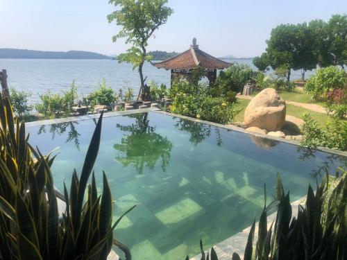 a swimming pool with a view of the water at Wooden Homestay Đại Lải in Phúc Yên