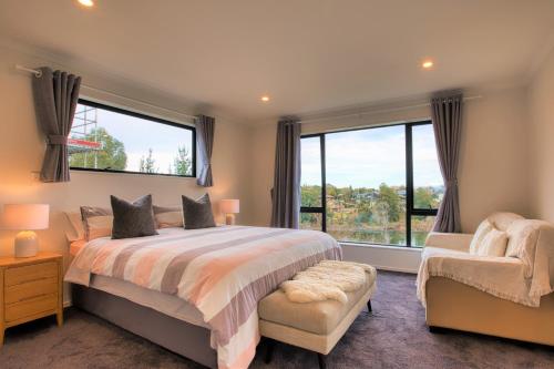 a bedroom with a bed and a large window at Wonderful River View-Brand New Home - 4 Bedrooms in Hamilton