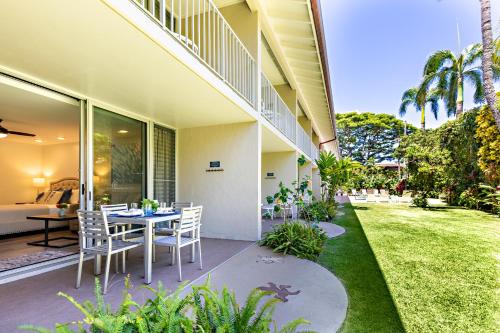 eine Terrasse eines Hauses mit einem Tisch und Stühlen in der Unterkunft Napili Puamala 128 in Kahana