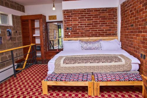 a bed in a room with a brick wall at Jabulani Private Villas in Arusha
