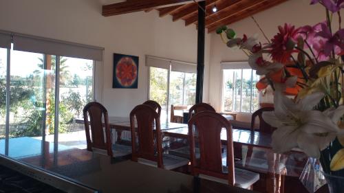uma mesa de jantar com cadeiras e um vaso de flores em Los Moros Country em San Rafael