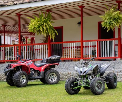 two atvs and a quad bike parked in front of a house at Hotel Rural SAN REMO in Santa Rosa de Cabal