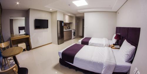 a hotel room with a bed and a television at J Hotel in Ulaanbaatar