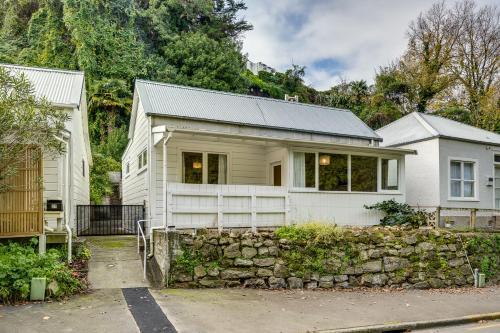 a white house with a stone wall at Central Cottage - Napier Holiday Home in Napier