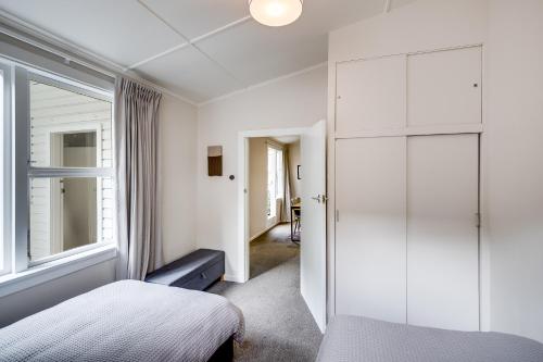 - une chambre avec un lit et une fenêtre dans l'établissement Central Cottage - Napier Holiday Home, à Napier