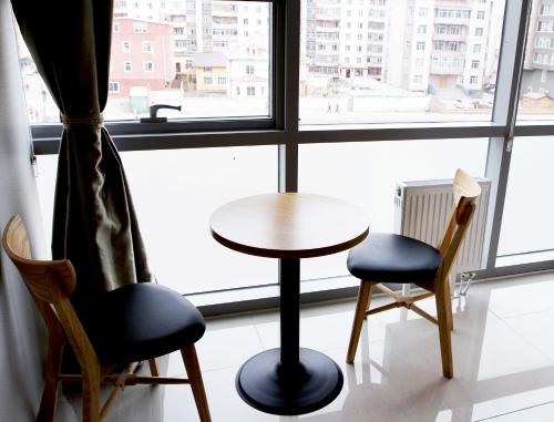 a table and two chairs in front of a window at J Hotel in Ulaanbaatar