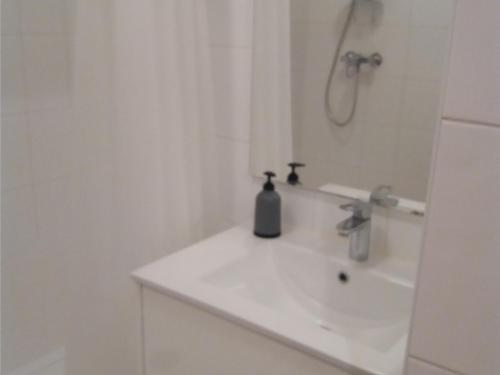 ein weißes Bad mit einem Waschbecken und einer Dusche in der Unterkunft Studio Les Sables-d'Olonne, 1 pièce, 3 personnes - FR-1-331-202 in Les Sables-dʼOlonne