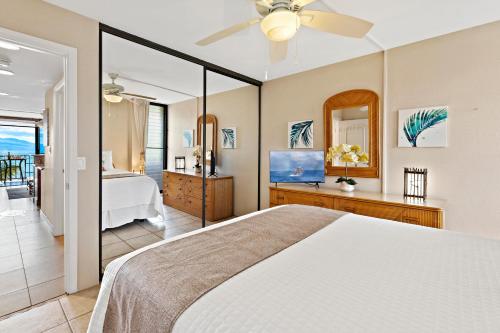 a bedroom with a bed and a view of a bathroom at Maalaea Banyans 314 in Wailuku